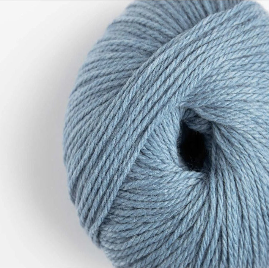 Close-up of a ball of light blue yarn on a white background