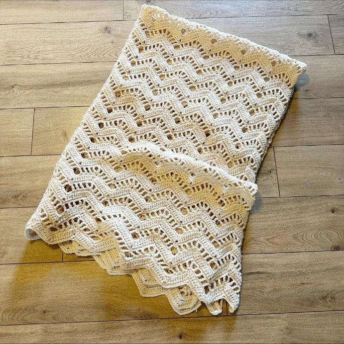 White lace crocheted vintage blanket shown folded
