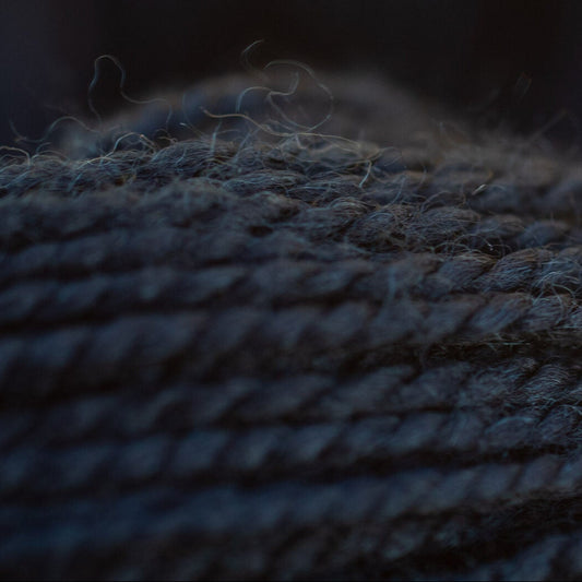 Close-up of textured dark fabric with a blurred background