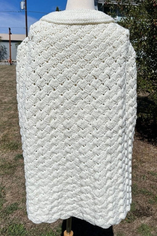 White textured garment on a mannequin outdoors with a blue sky background