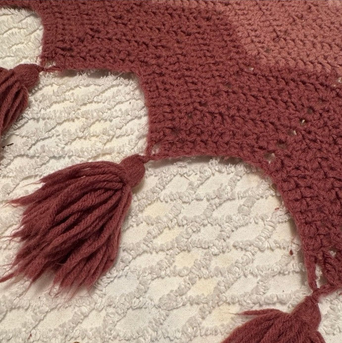 Close-up of a textured fabric with tassels on a phone screen