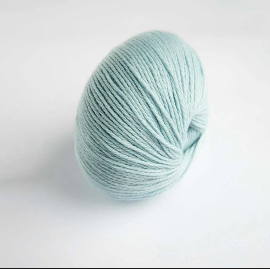 Light blue skein of yarn on a white background
