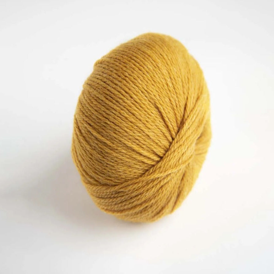 Ball of yellow yarn on a white background