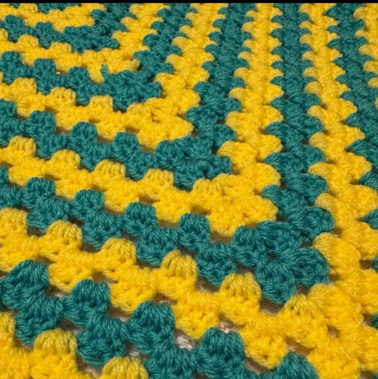 Close-up of a crocheted blanket with green and yellow pattern