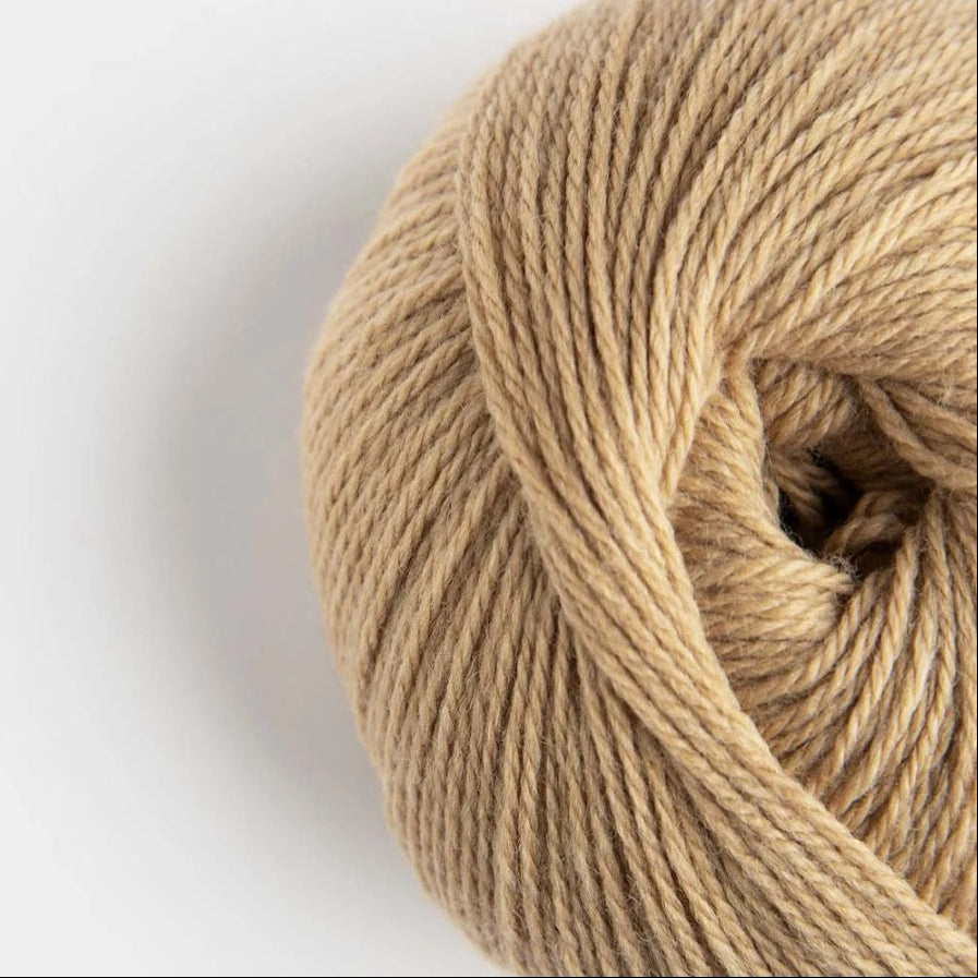 Close-up of a ball of beige yarn on a white background