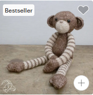 Stuffed monkey toy with knitted pattern on a wooden surface, labeled as a bestseller.
