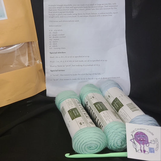 Yarn, an envelope, and a paper with text on a dark surface