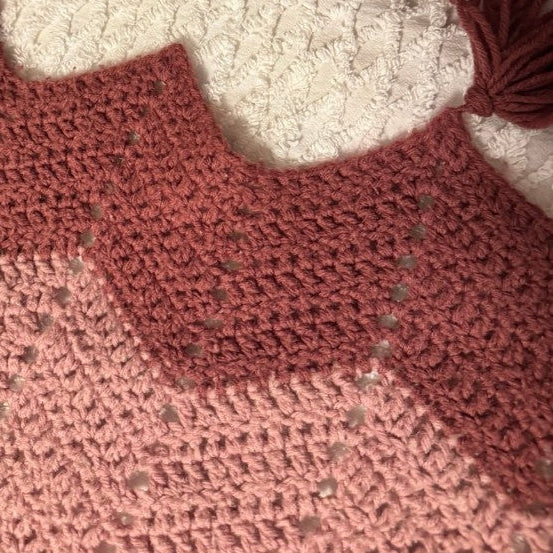 Close-up of a crocheted blanket with a chevron pattern in red and white.