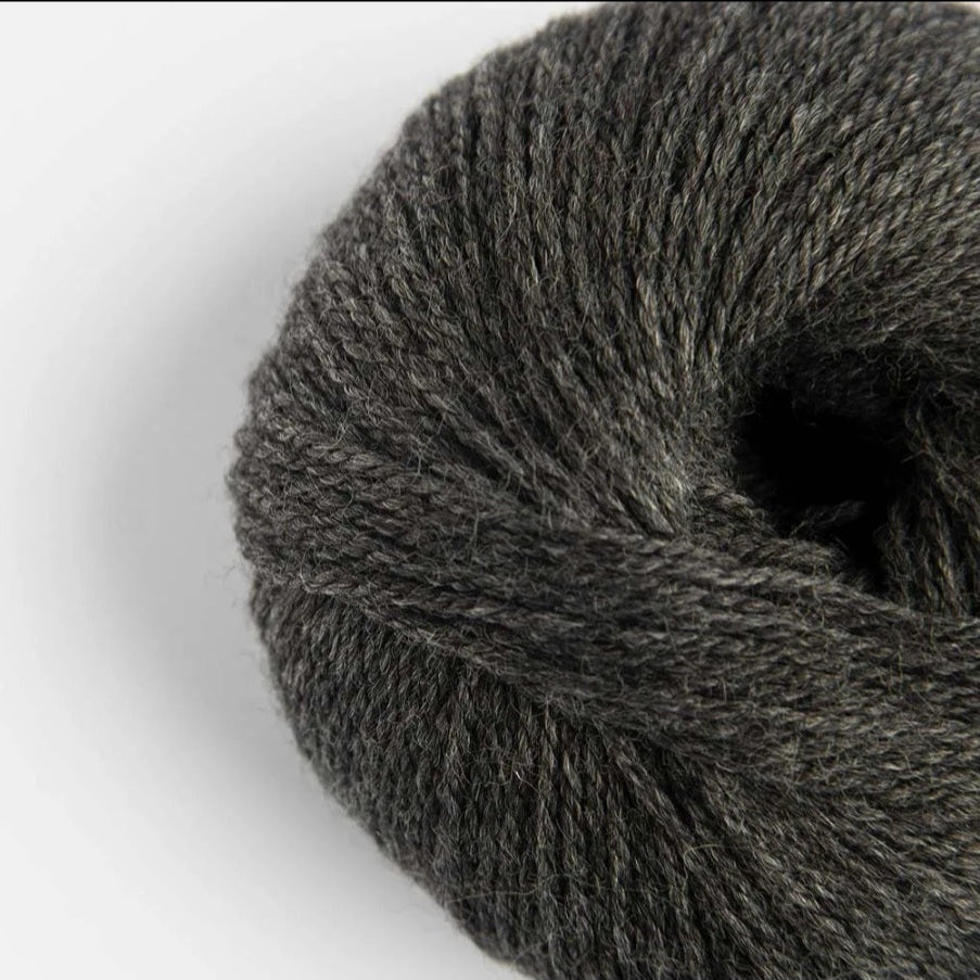 Close-up of a ball of dark gray yarn on a white background