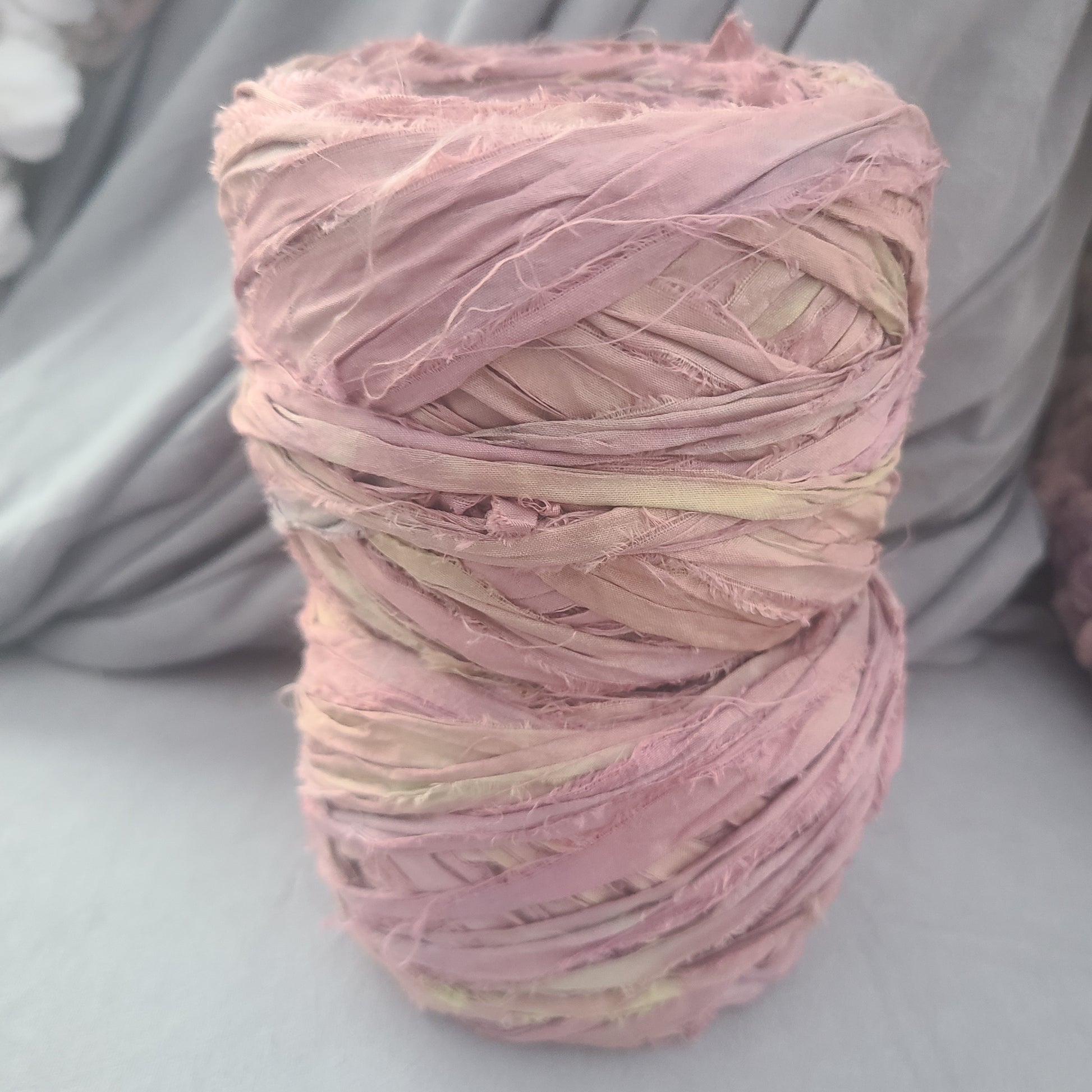 Ball of pink yarn on a gray surface