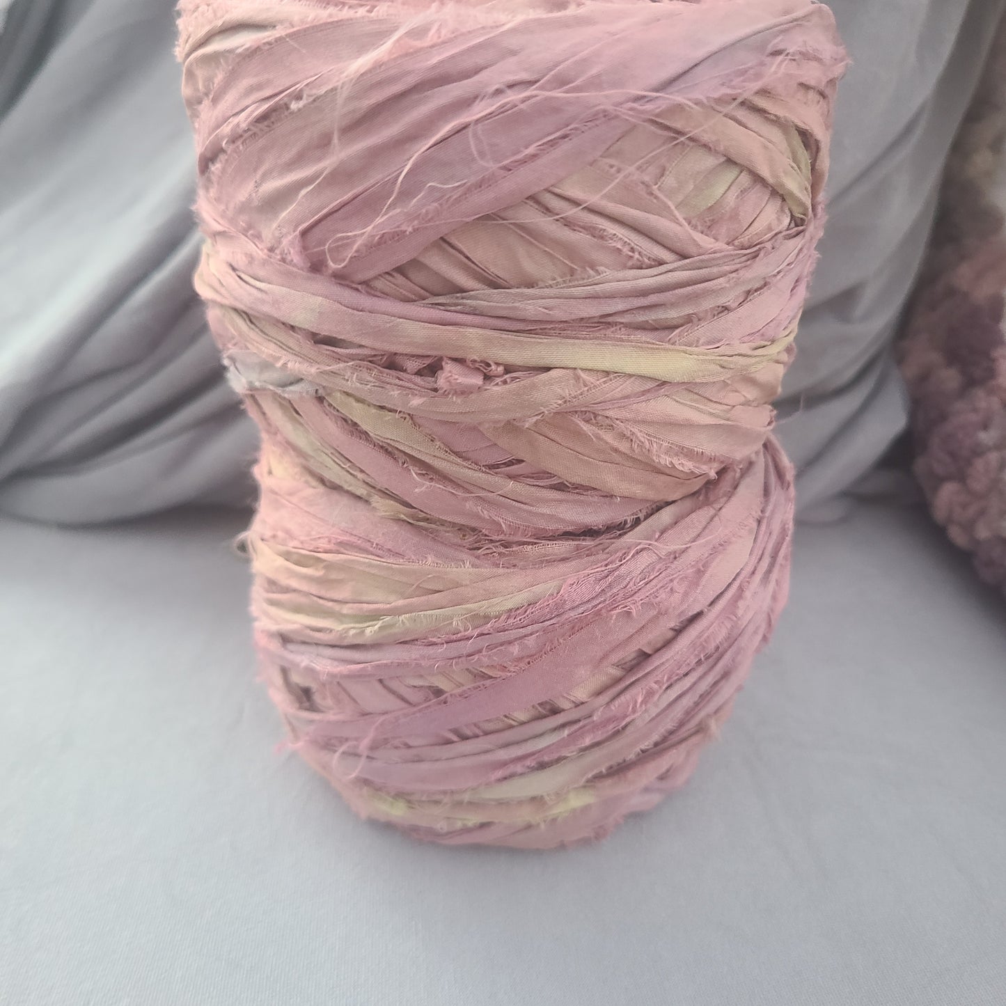 Ball of pink yarn on a gray surface