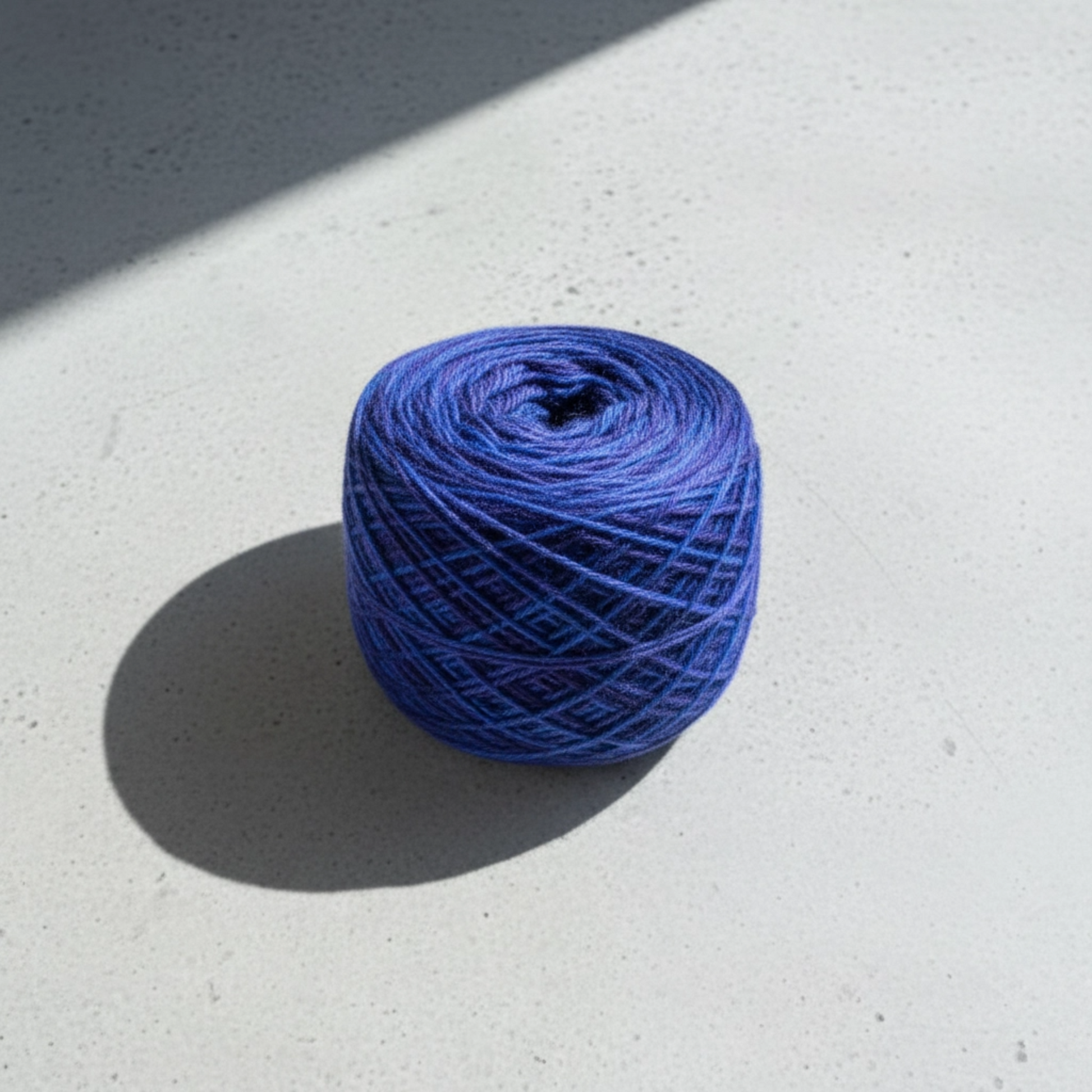 Blue yarn ball on a light gray surface