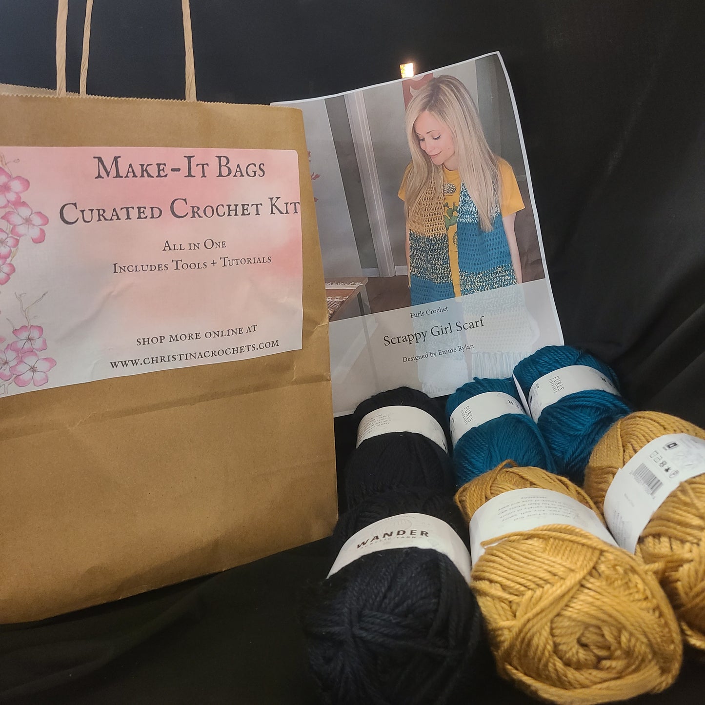 Yarn balls and a crochet kit on a dark surface