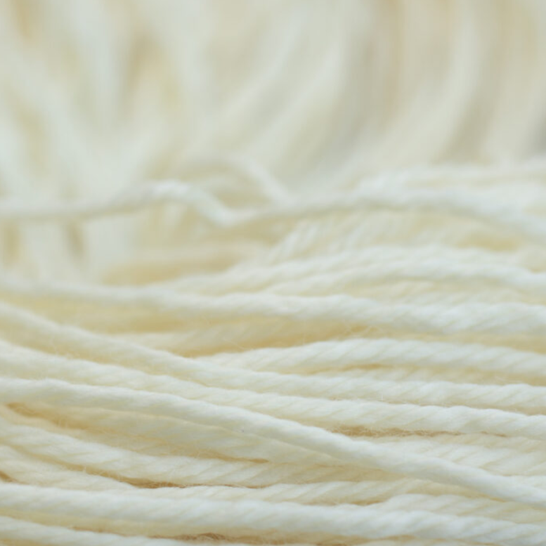 Close-up of cream-colored yarn on a light background
