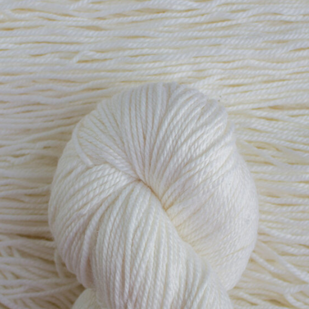 Close-up of a ball of white yarn on a textured white background