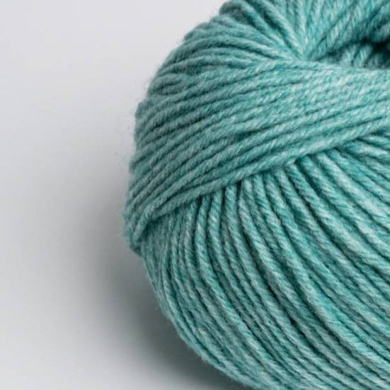 Turquoise skein of yarn on a light gray background