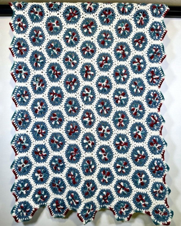 Crocheted blanket with a geometric pattern on a white background