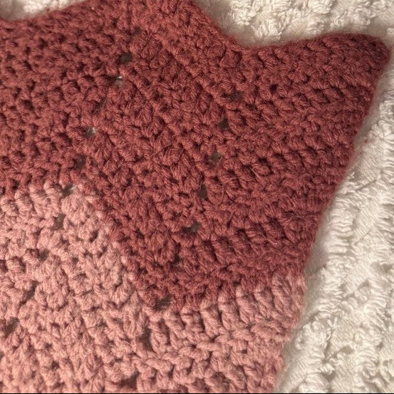 Close-up of a textured fabric with a pink and white pattern, possibly a rug or blanket.