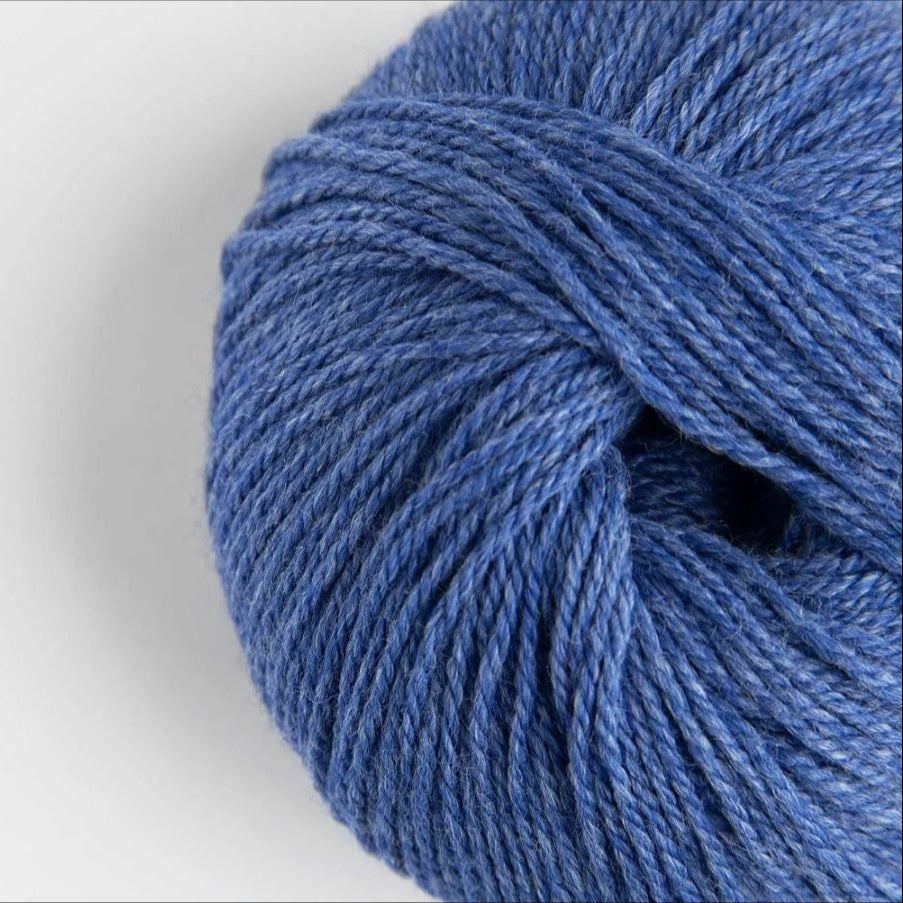 Close-up of a blue skein of yarn on a light gray background