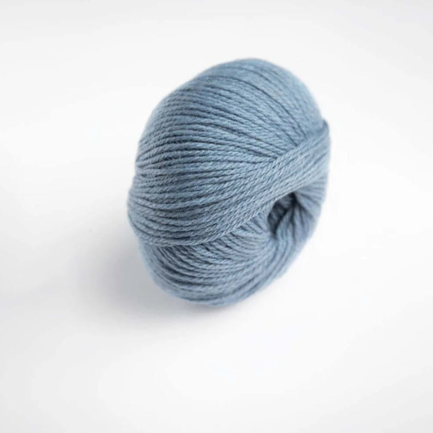 Ball of light blue yarn on a white background