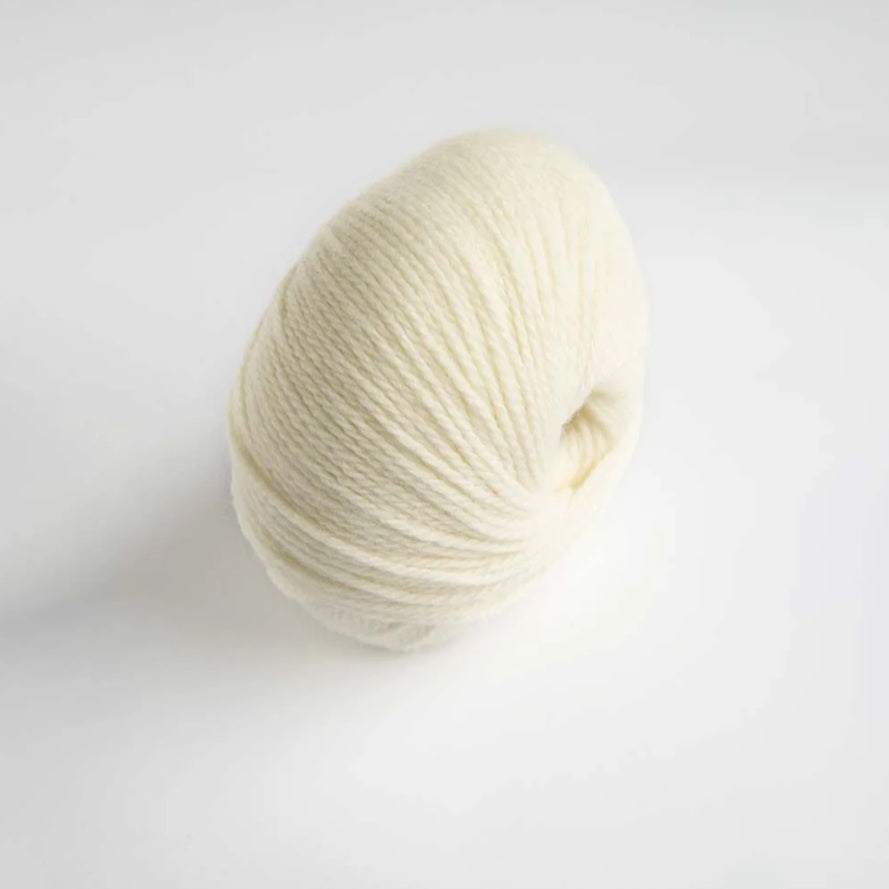 Ball of cream-colored yarn on a light gray background