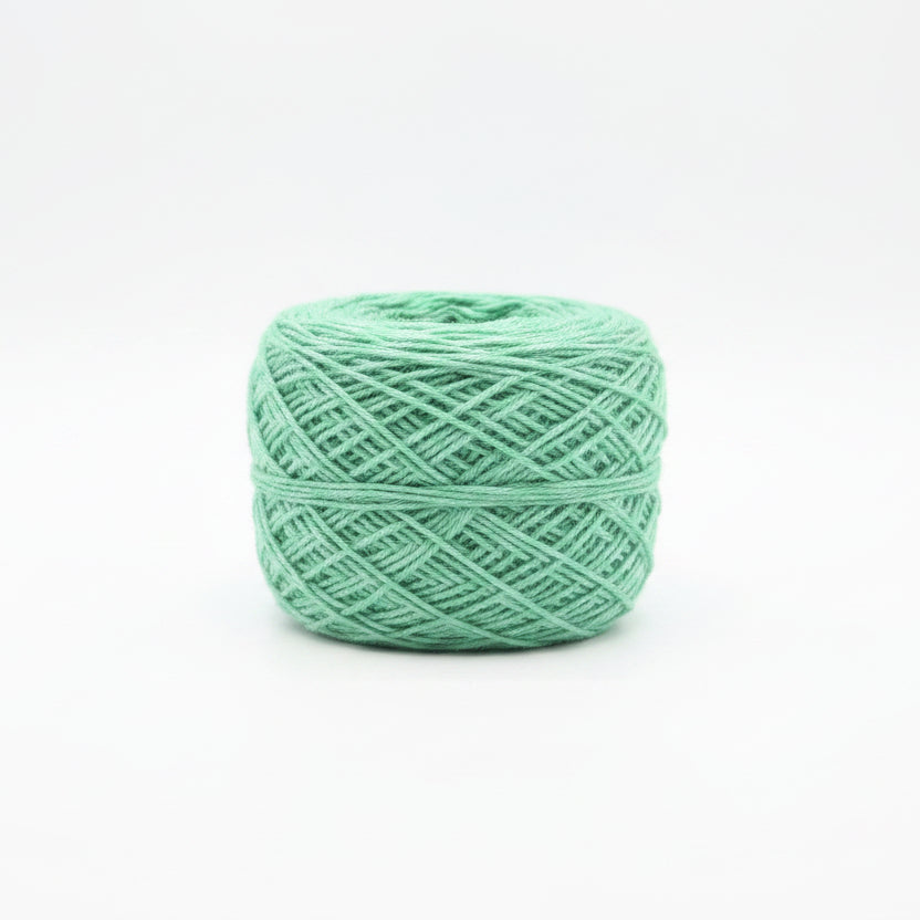 Ball of green yarn on a white background