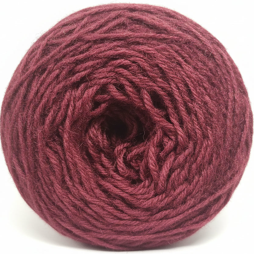 Close-up of a ball of dark red yarn on a gray background