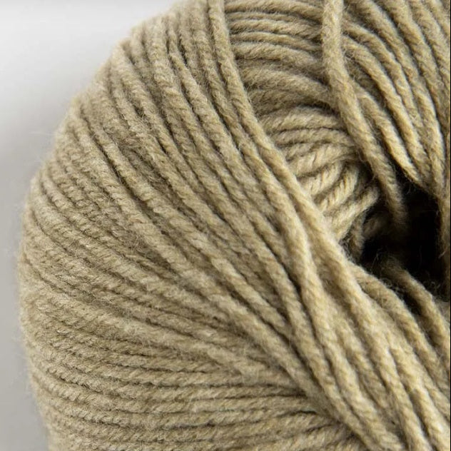 Ball of beige yarn on a white background