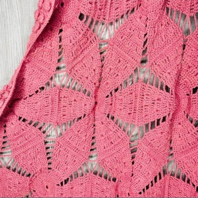 Close-up of a vintage pink lace blanket with diamond pattern