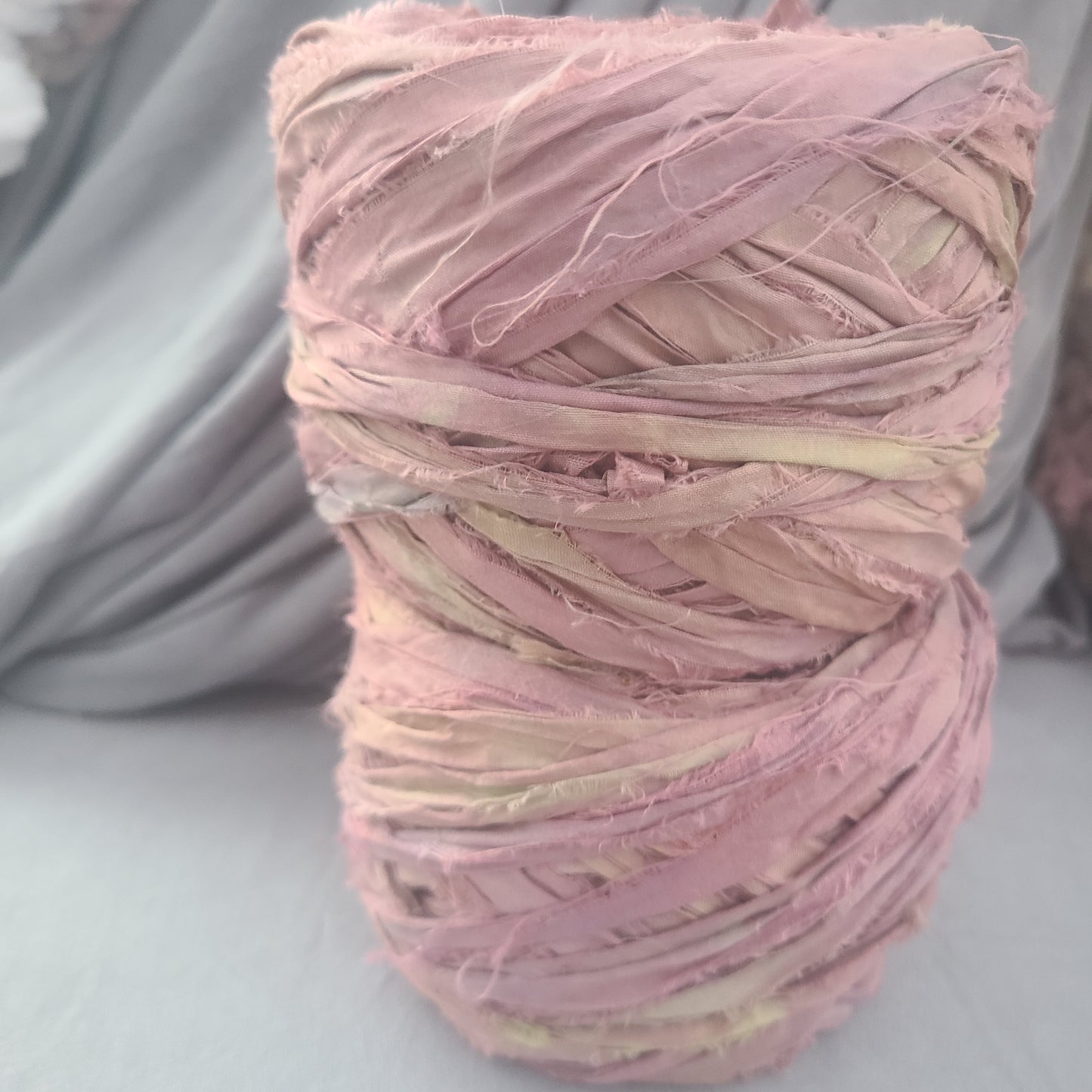 Ball of pink yarn on a gray surface