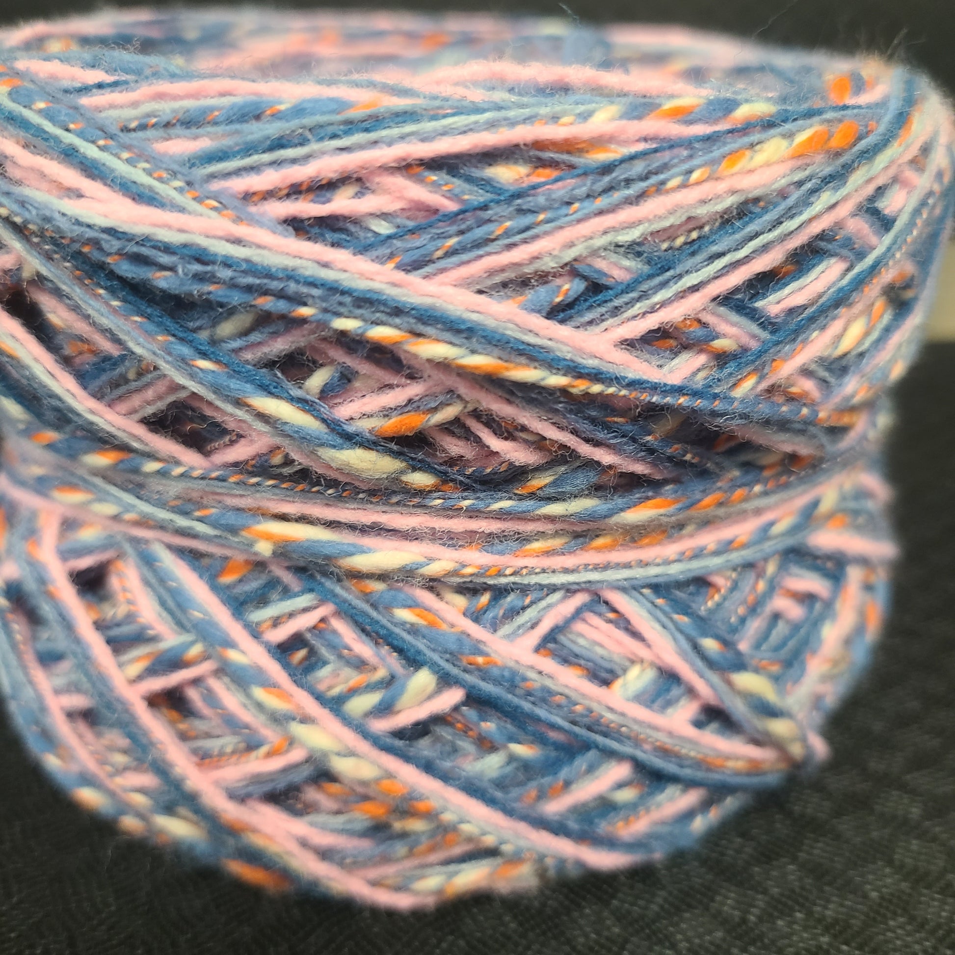 Multicolored yarn ball on a black background