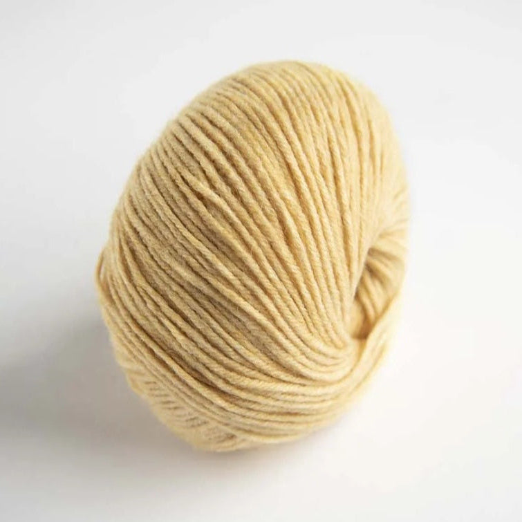 Ball of beige yarn on a white background