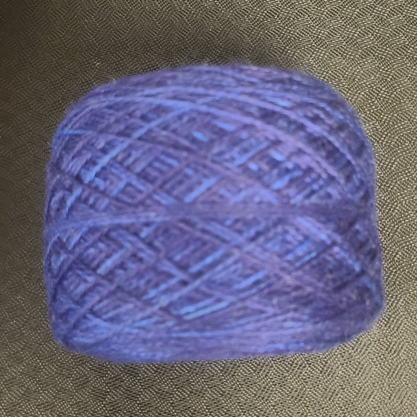 Blue skein of yarn on a textured brown background