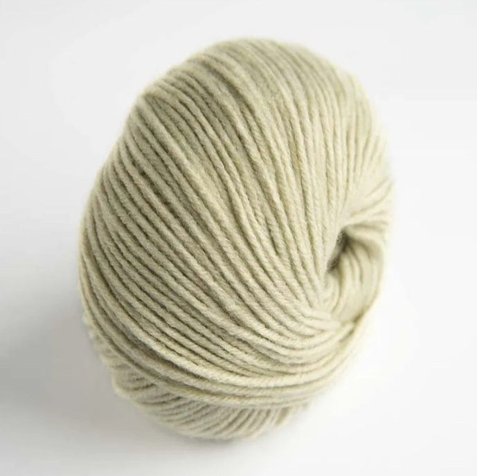 Ball of beige yarn on a white background
