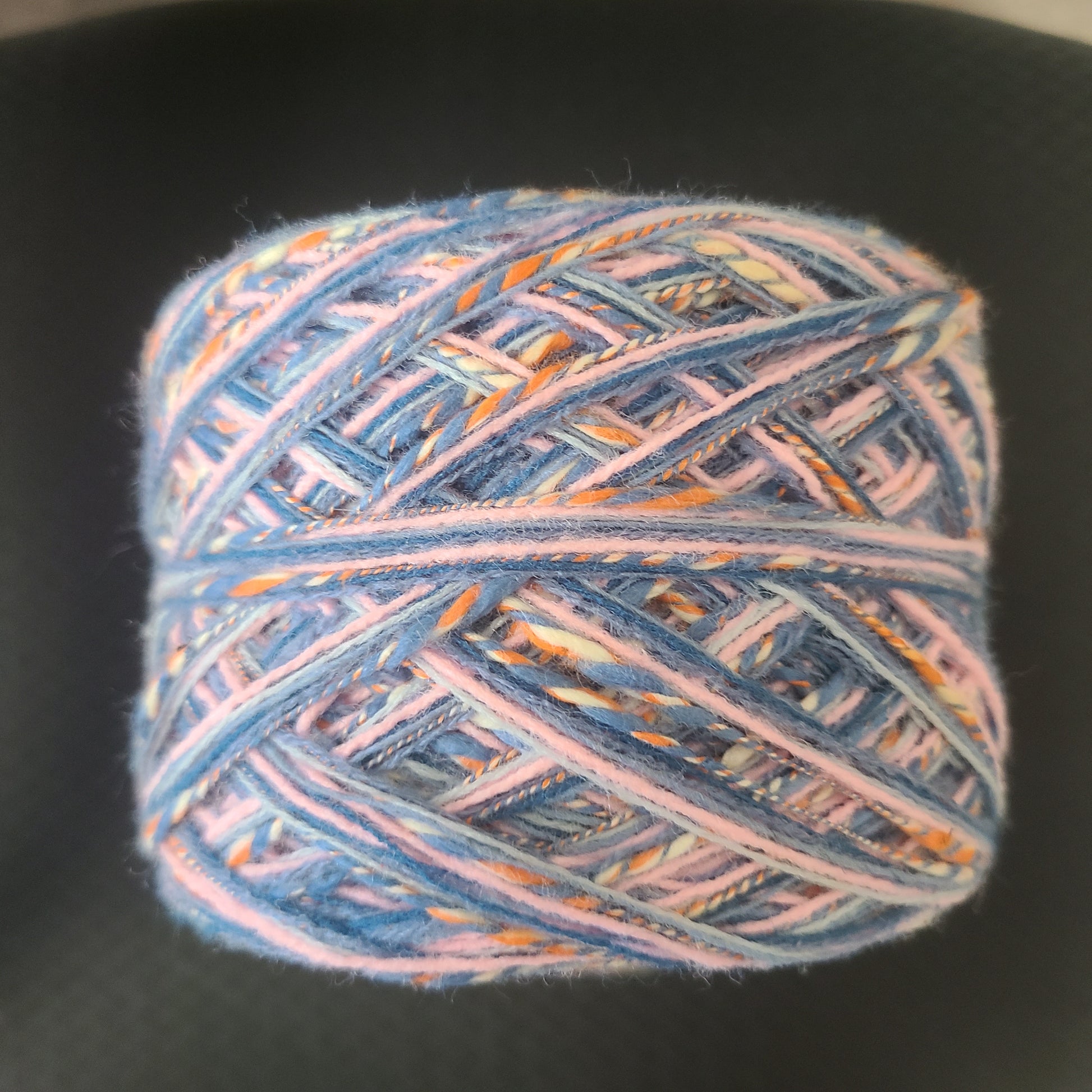 Multicolored yarn ball on a black background